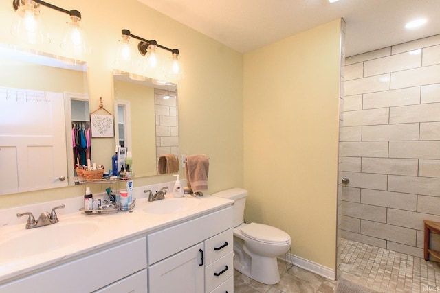 bathroom featuring tiled shower, vanity, and toilet