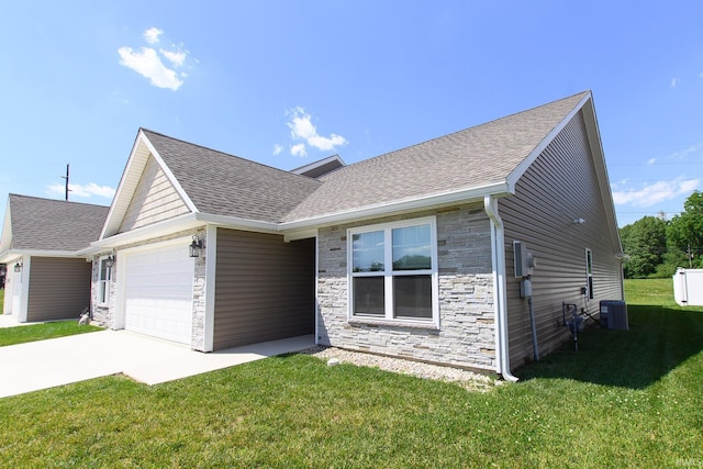 ranch-style house featuring a front yard, a garage, and central AC unit