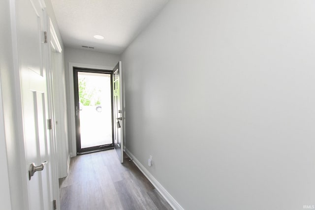 doorway with wood-type flooring and a textured ceiling