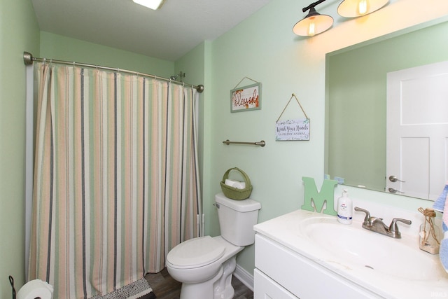 bathroom featuring curtained shower, vanity, wood-type flooring, and toilet