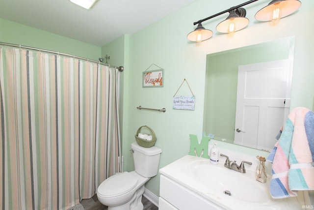 bathroom with curtained shower, vanity, and toilet