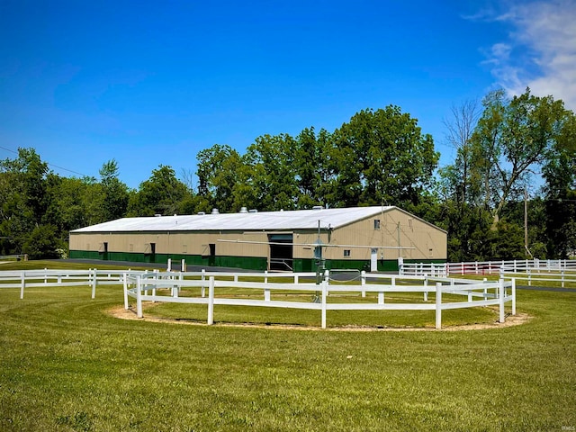 view of horse barn featuring a rural view and a yard