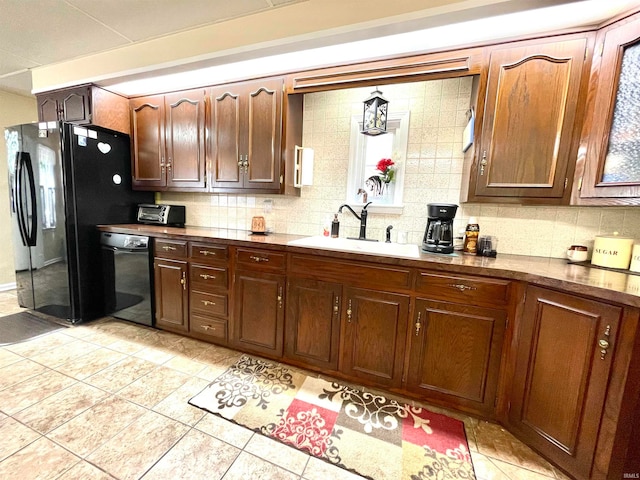 kitchen featuring backsplash, sink, black appliances, and light tile floors