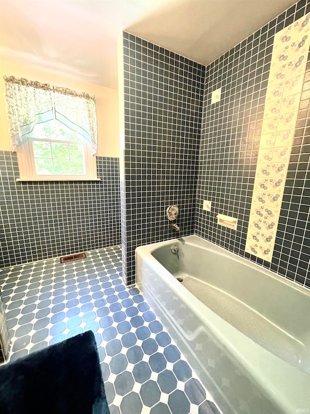 bathroom featuring tile walls, tile floors, and tiled shower / bath combo