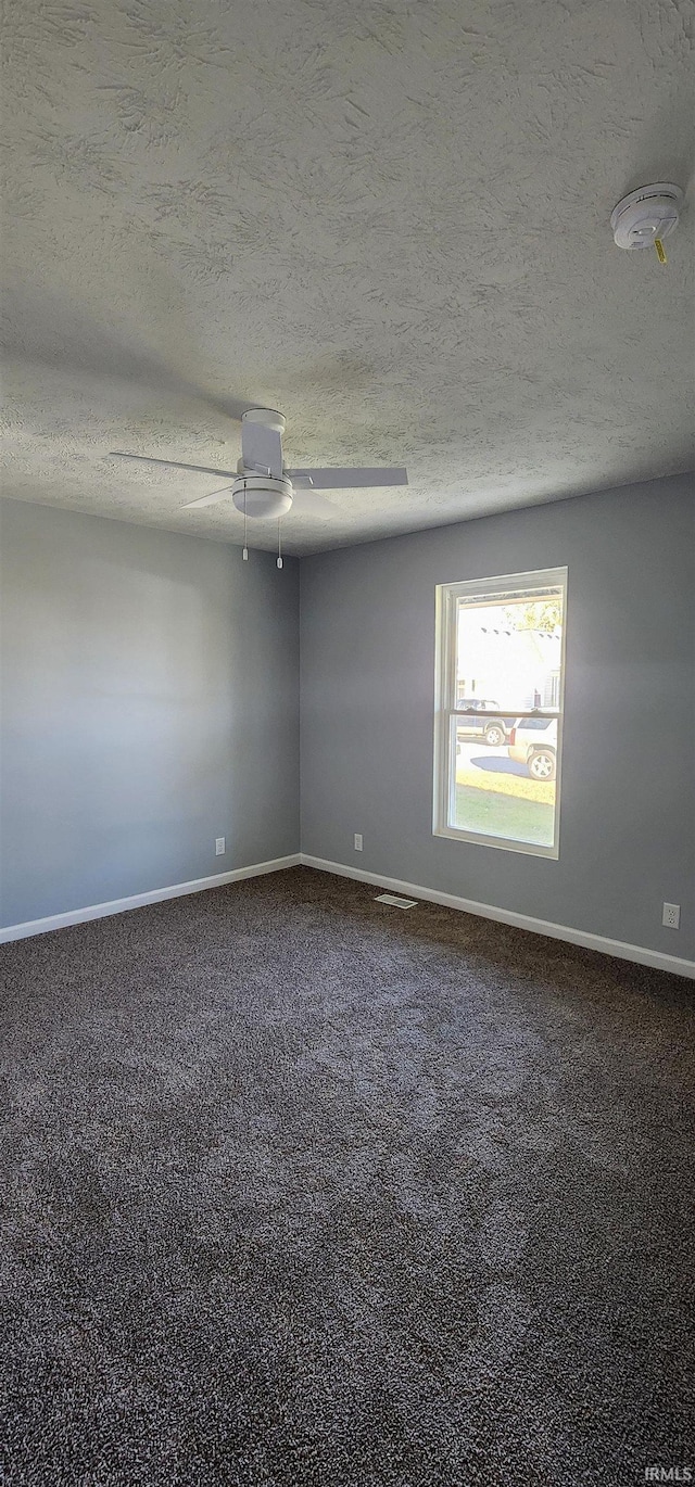 empty room with a textured ceiling and ceiling fan