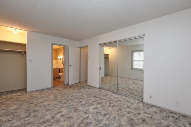 unfurnished bedroom featuring carpet floors and ensuite bath