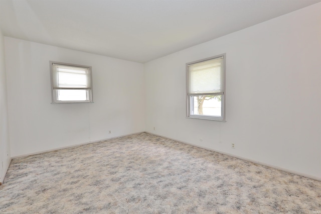 carpeted spare room featuring plenty of natural light