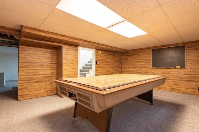 game room with a paneled ceiling, wooden walls, and carpet floors