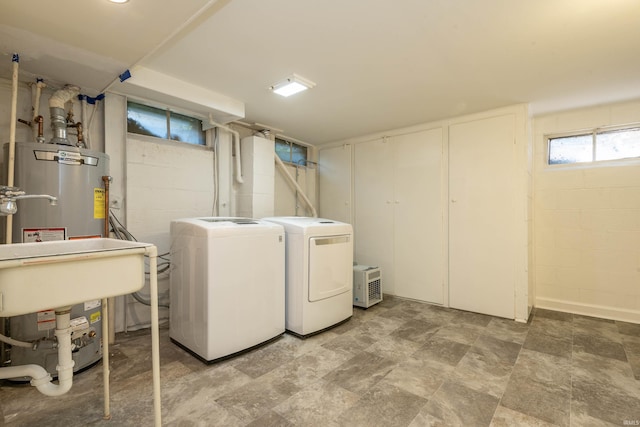 washroom with washing machine and dryer and gas water heater