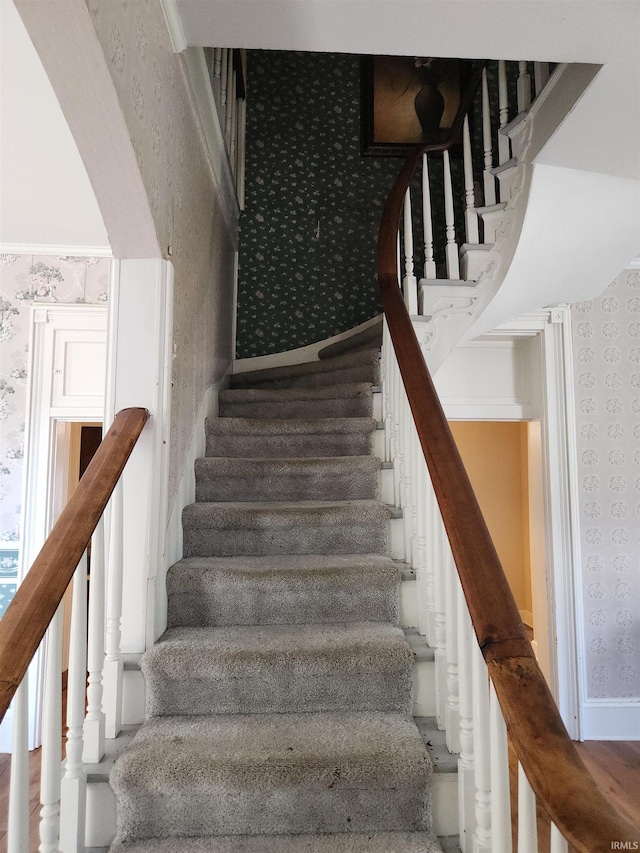 stairs featuring wallpapered walls and baseboards