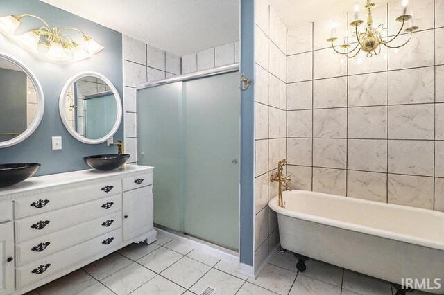 bathroom featuring vanity, tile walls, independent shower and bath, and a notable chandelier