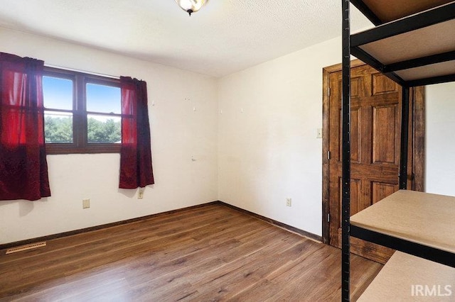 unfurnished room with wood-type flooring