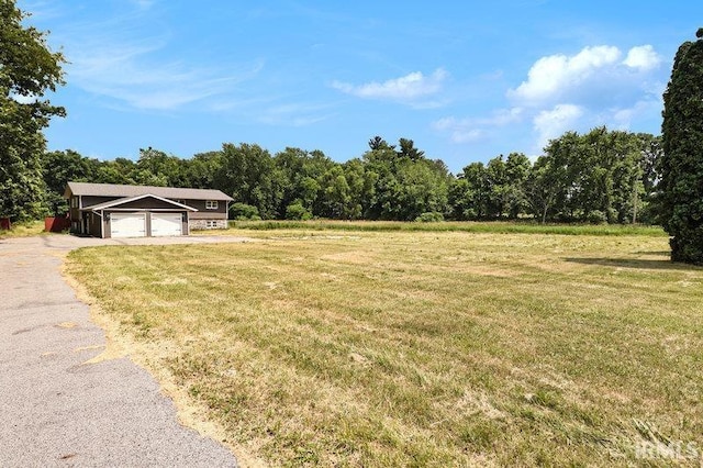 view of yard with a garage and a rural view