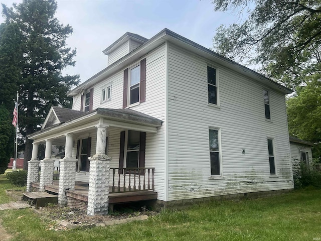 view of home's exterior with a lawn and a porch