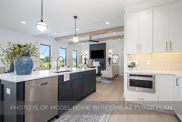 kitchen with ceiling fan, beamed ceiling, dishwasher, white cabinetry, and hanging light fixtures