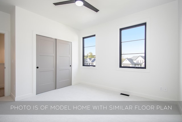 unfurnished bedroom with ceiling fan, carpet floors, and a closet