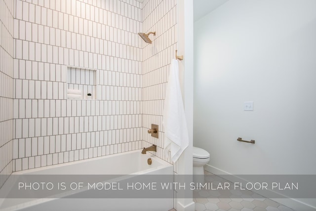 bathroom featuring tile patterned floors, tiled shower / bath, and toilet