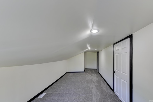 additional living space with vaulted ceiling and light colored carpet