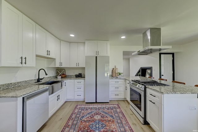 kitchen with sink, white cabinetry, stainless steel appliances, light stone countertops, and island exhaust hood