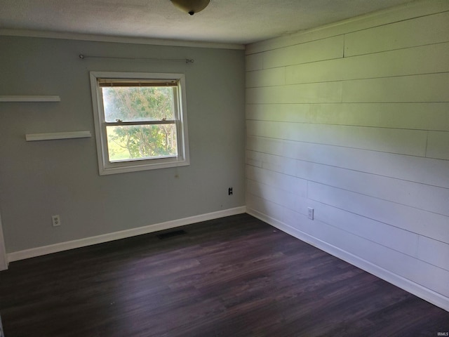 unfurnished room with a textured ceiling and dark wood-type flooring