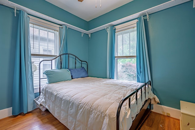 bedroom featuring multiple windows, ceiling fan, and wood-type flooring