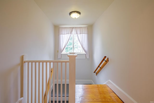 stairway with hardwood / wood-style floors and a baseboard radiator