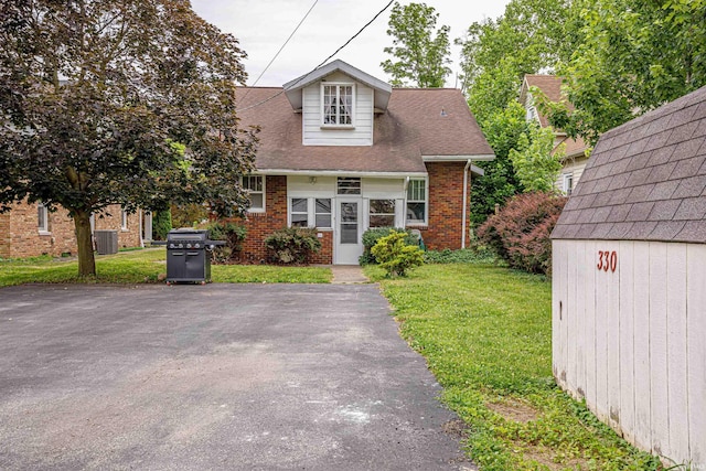 view of front facade with a shed and a front lawn