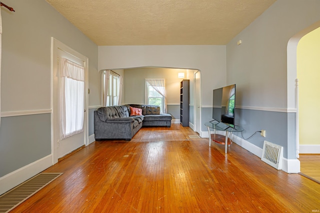 unfurnished living room with hardwood / wood-style floors and a textured ceiling