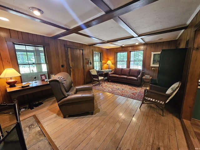 living room featuring beamed ceiling, a healthy amount of sunlight, light hardwood / wood-style floors, and coffered ceiling