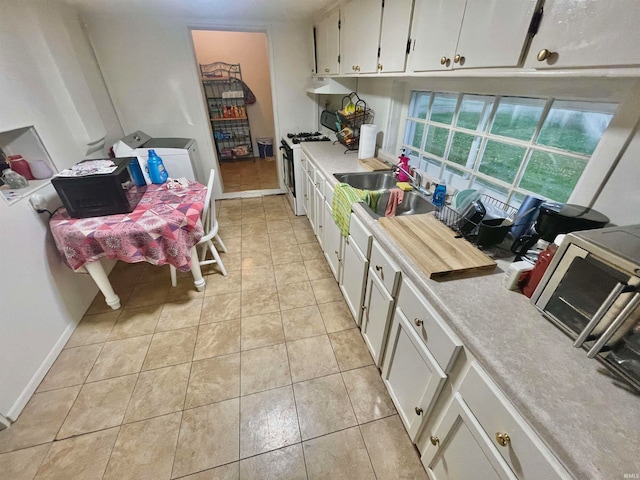 kitchen with white cabinetry, white appliances, sink, and light tile patterned floors