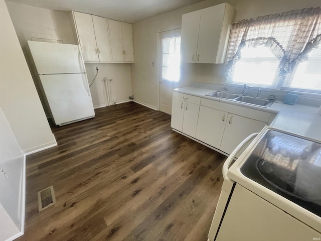 kitchen featuring white cabinets, sink, dark hardwood / wood-style floors, white fridge, and range