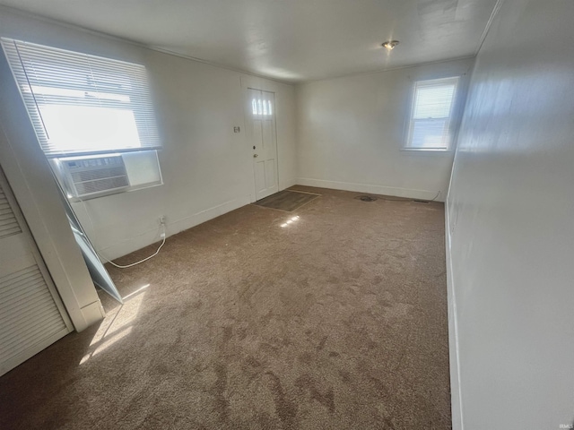 carpeted empty room with plenty of natural light and cooling unit