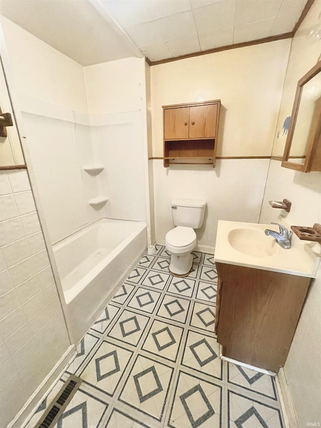 full bathroom featuring vanity, tile patterned floors, crown molding, shower / washtub combination, and toilet