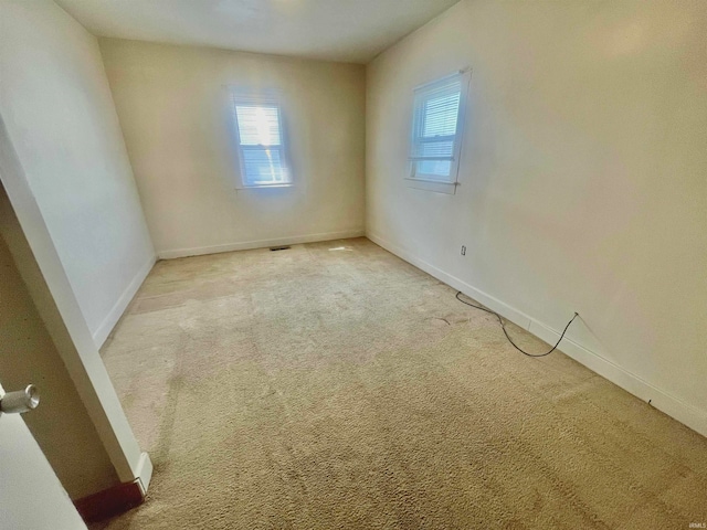 spare room featuring light carpet