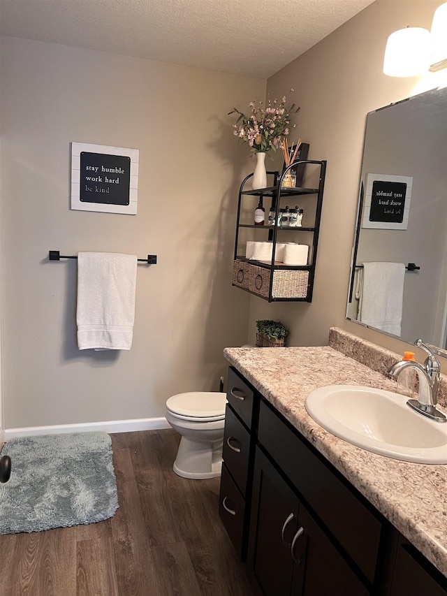 bathroom featuring toilet, vanity, a textured ceiling, and hardwood / wood-style flooring