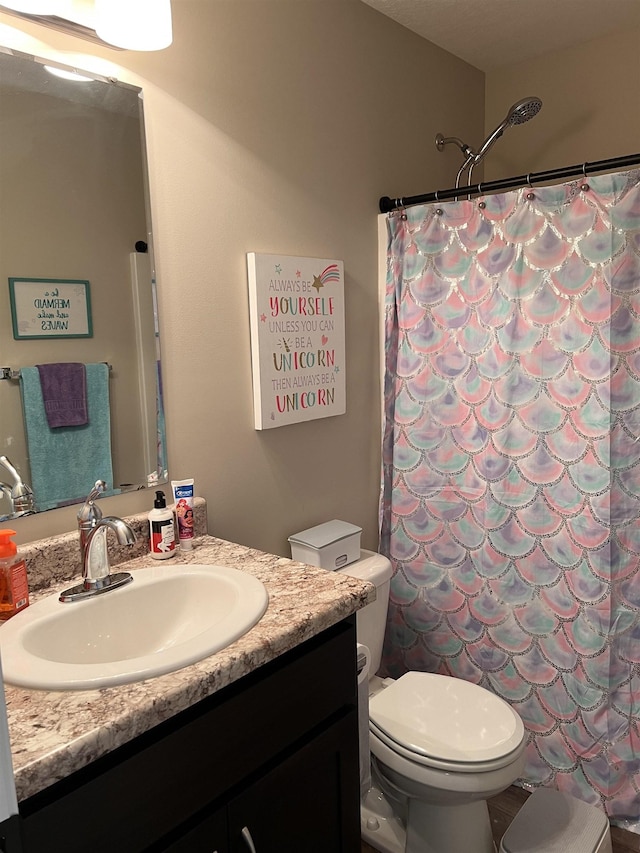 bathroom with a shower with curtain, vanity, and toilet