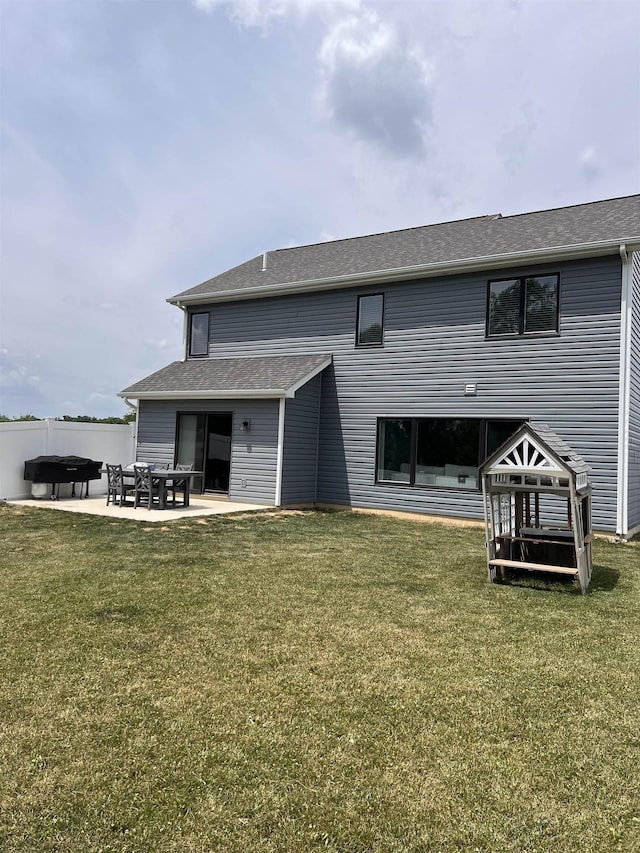 rear view of house with a lawn and a patio