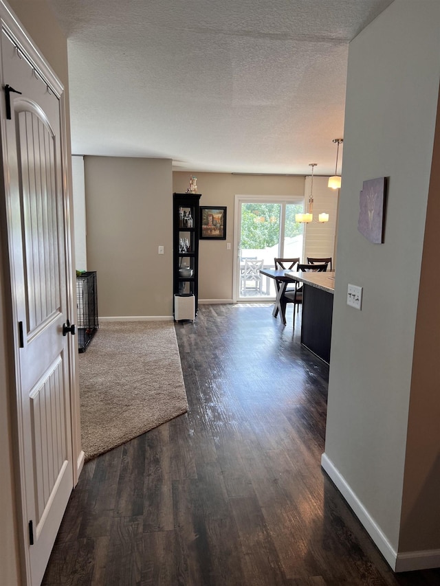 hallway featuring dark hardwood / wood-style flooring and a textured ceiling