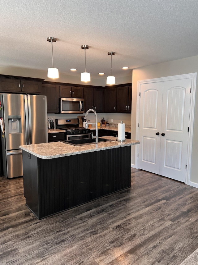 kitchen featuring sink, an island with sink, decorative light fixtures, and appliances with stainless steel finishes