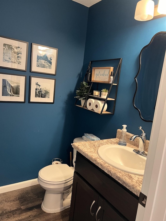 bathroom with vanity, hardwood / wood-style flooring, and toilet