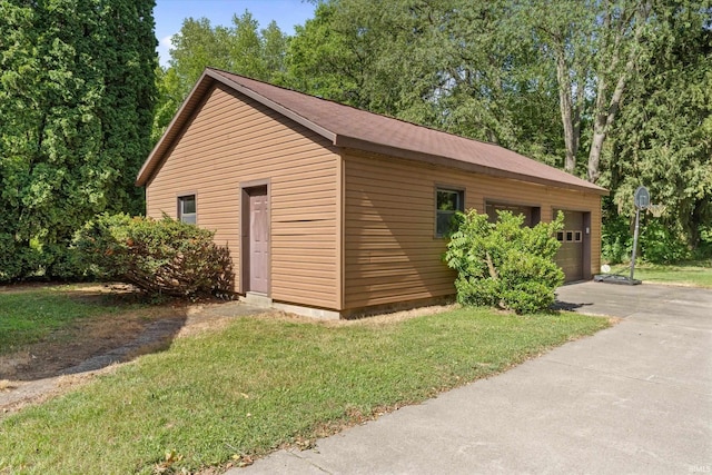 view of outbuilding featuring a garage and a lawn