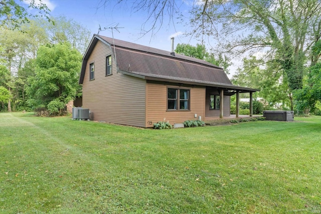 view of side of home with a lawn and central AC