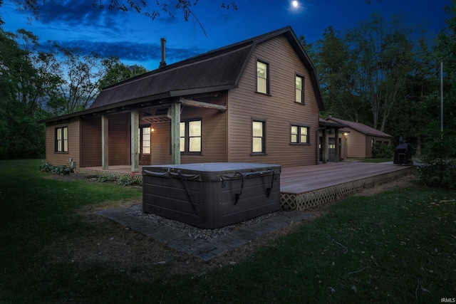 property exterior at dusk with a yard and a hot tub