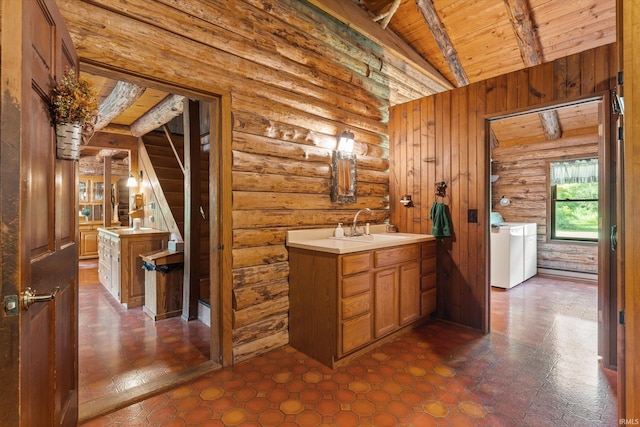 bathroom featuring vanity, wooden ceiling, lofted ceiling with beams, washing machine and dryer, and log walls