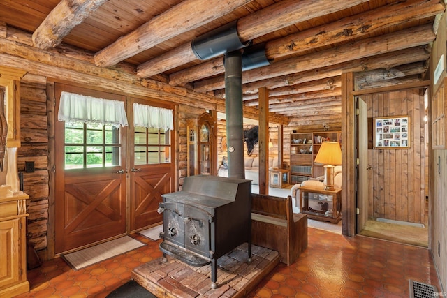 misc room featuring beam ceiling, rustic walls, dark tile patterned floors, and wooden ceiling