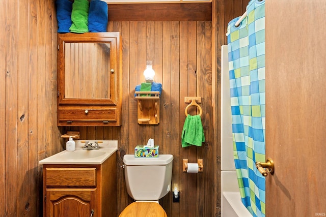 full bathroom with shower / tub combo, vanity, toilet, and wooden walls