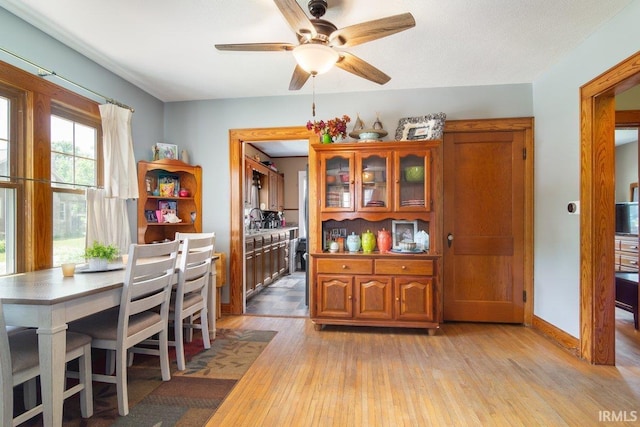 dining area with ceiling fan, light hardwood / wood-style floors, and sink