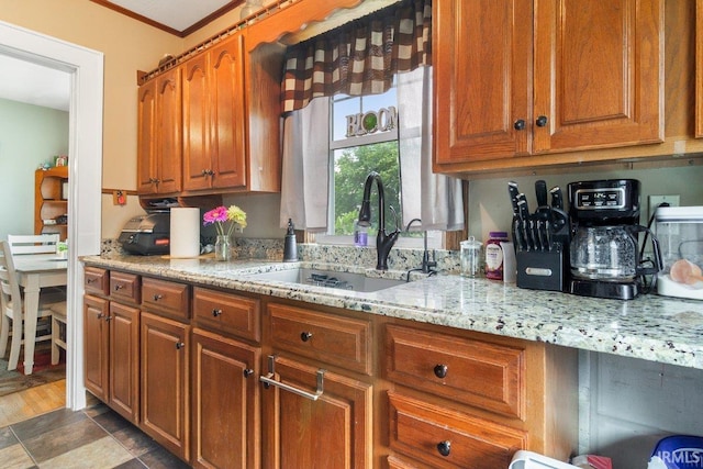 kitchen featuring tile floors, sink, ornamental molding, and light stone countertops