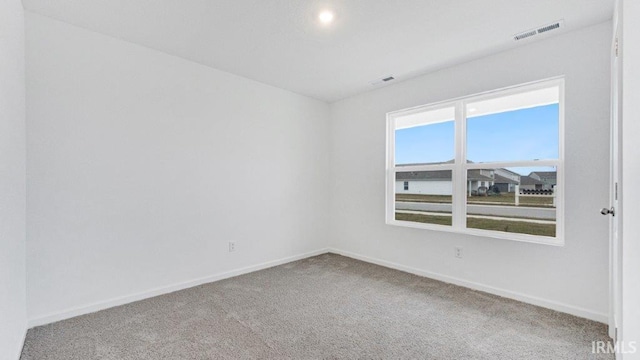 carpeted empty room with baseboards and visible vents