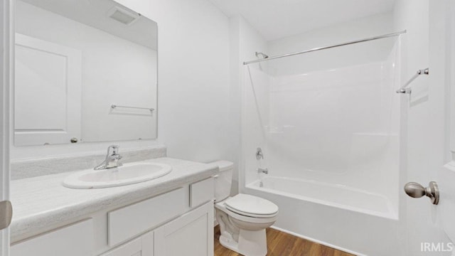 bathroom with toilet, bathtub / shower combination, wood finished floors, and vanity